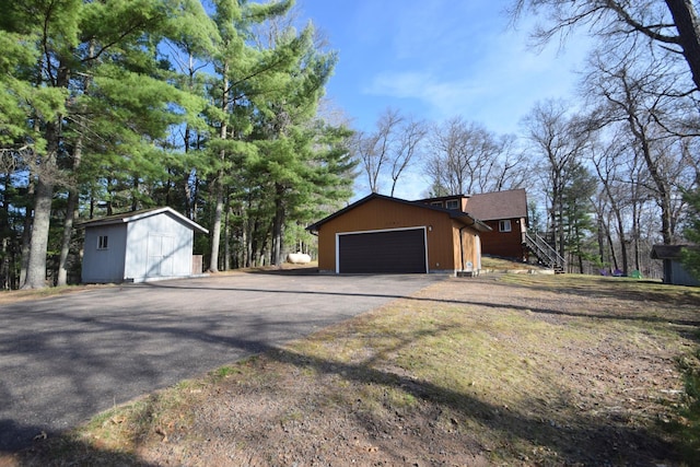 3585 Rigby Rd, Webster, WI 54893 - view of side of home featuring an outdoor structure, an attached garage, and aphalt driveway