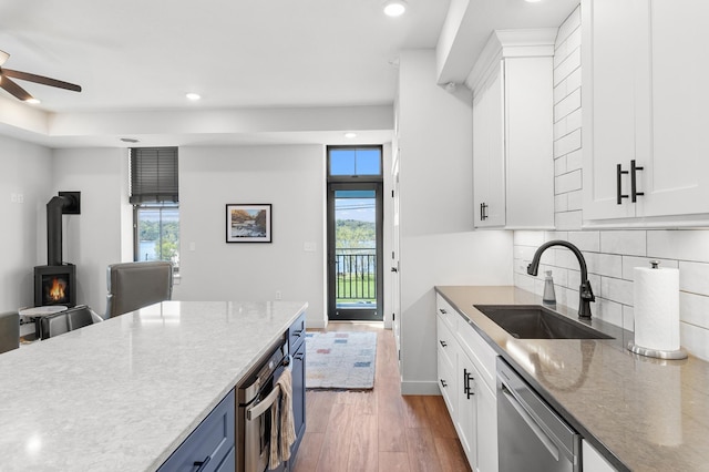 517 2nd St Unit 303, Hudson, WI 54016 - kitchen featuring a sink, stainless steel appliances, dark wood-style floors, a wood stove, and ceiling fan