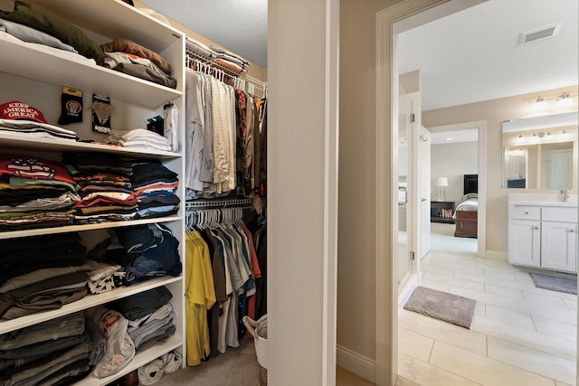 walk in closet with visible vents and a sink