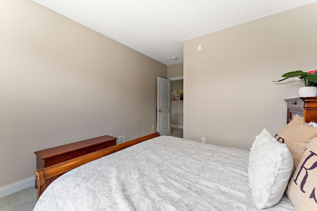 bedroom featuring baseboards, visible vents, and carpet