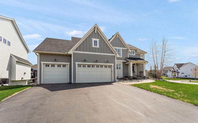 craftsman house featuring a garage, a front lawn, board and batten siding, central air condition unit, and driveway