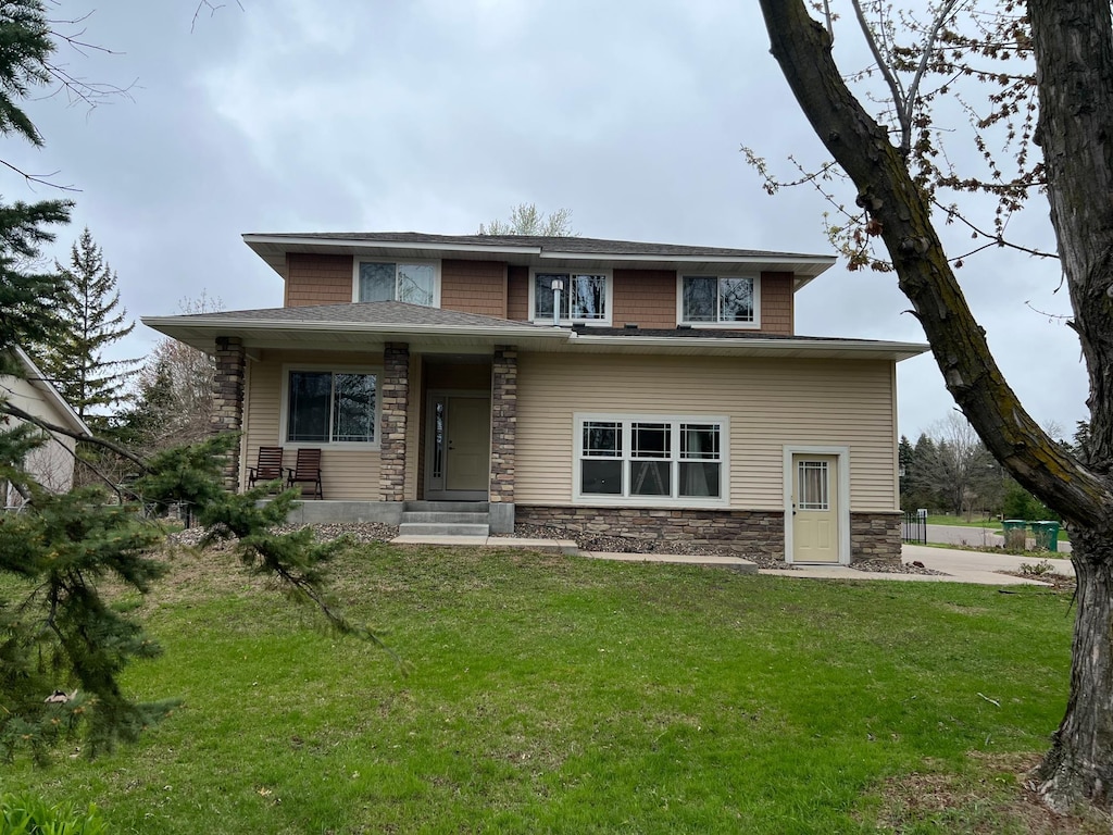 prairie-style home with a front lawn and stone siding