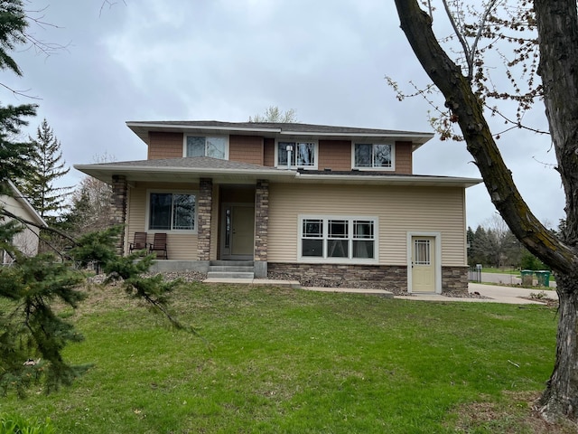 prairie-style home with a front lawn and stone siding