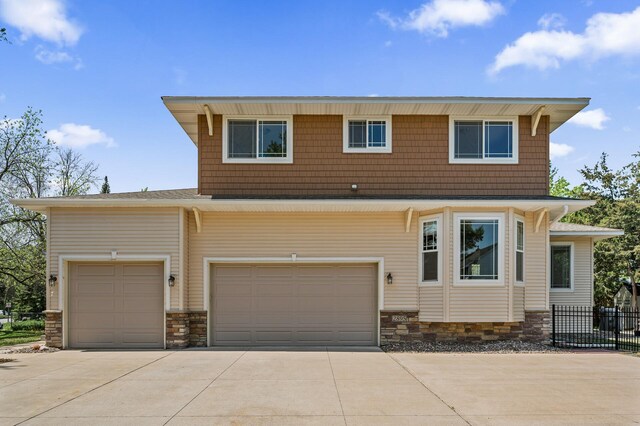 2895 Thunder Bay Ct, Little Canada, MN 55117 - view of front of property featuring driveway, stone siding, fence, and an attached garage