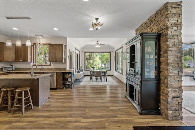 2895 Thunder Bay Ct, Little Canada, MN 55117 - kitchen featuring a textured ceiling, dark wood-type flooring, ceiling fan, light stone countertops, and healthy amount of natural light