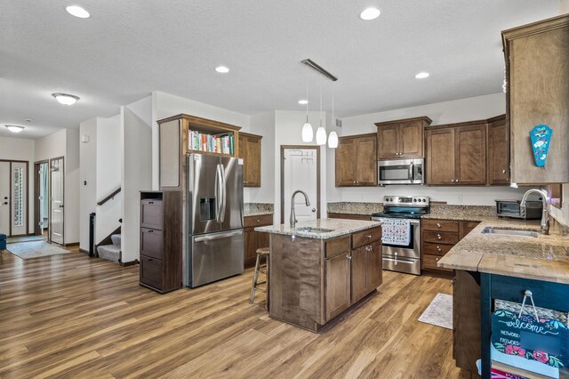 2895 Thunder Bay Ct, Little Canada, MN 55117 - kitchen featuring stainless steel appliances, a sink, open shelves, light wood finished floors, and recessed lighting
