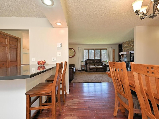 dining room featuring dark wood finished floors, a textured ceiling, and recessed lighting