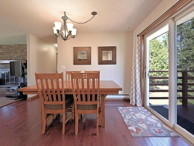 dining space featuring a textured ceiling, a notable chandelier, hardwood / wood-style floors, and baseboard heating