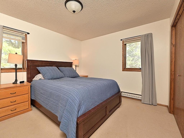 bedroom featuring light colored carpet, a textured ceiling, and baseboard heating