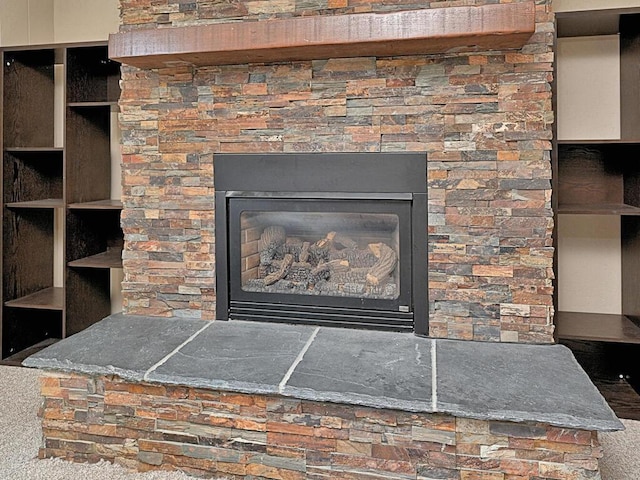 room details with a stone fireplace and carpet floors