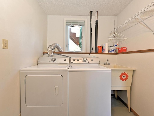 laundry area with laundry area, washer and clothes dryer, and a textured ceiling