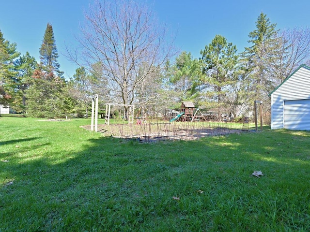 view of yard with a garage and a playground