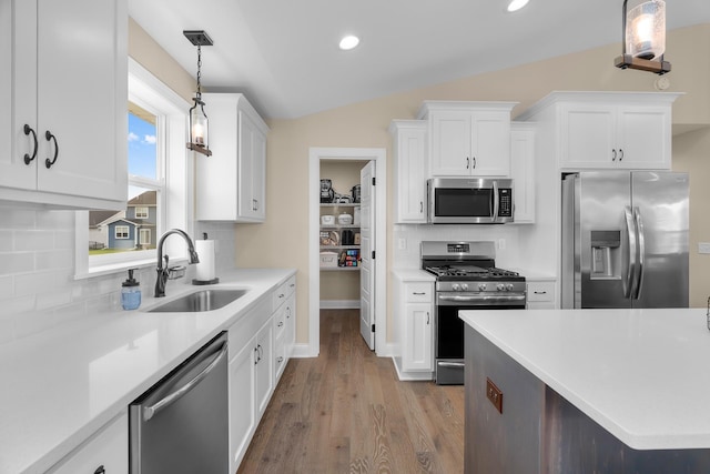 1581 Philipp Way, Shakopee, MN 55379 - kitchen with appliances with stainless steel finishes, vaulted ceiling, light countertops, white cabinets, and tasteful backsplash