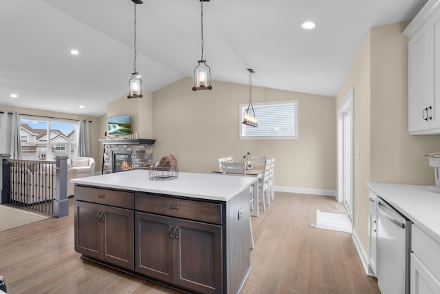 1581 Philipp Way, Shakopee, MN 55379 - kitchen featuring dishwasher, light wood-style flooring, a stone fireplace, vaulted ceiling, and light countertops
