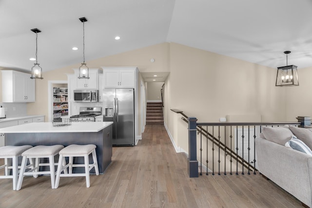 1581 Philipp Way, Shakopee, MN 55379 - kitchen featuring stainless steel appliances, lofted ceiling, a center island, light wood finished floors, and white cabinetry