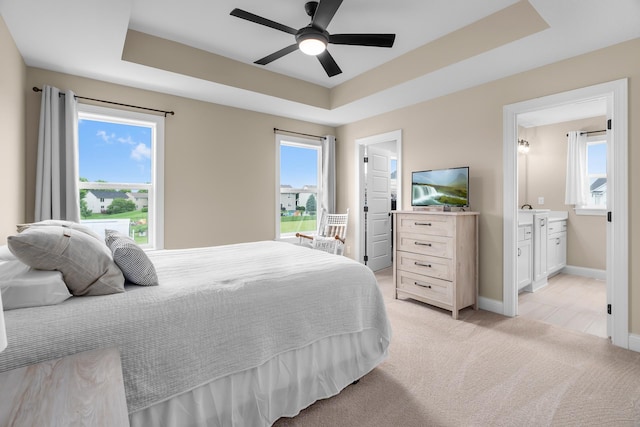 1581 Philipp Way, Shakopee, MN 55379 - bedroom featuring a raised ceiling, light carpet, ensuite bath, and a ceiling fan