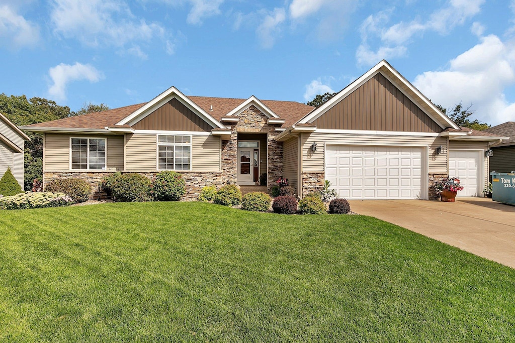 3160 Orchid Dr NE, Sauk Rapids, MN 56379 - view of front of house with an attached garage, a front yard, stone siding, and concrete driveway