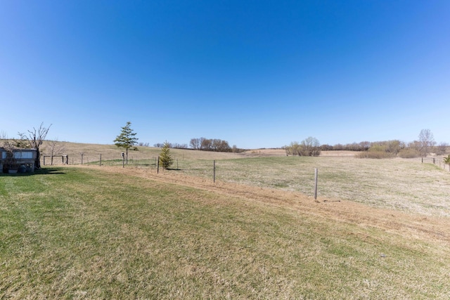 view of yard with a rural view and fence