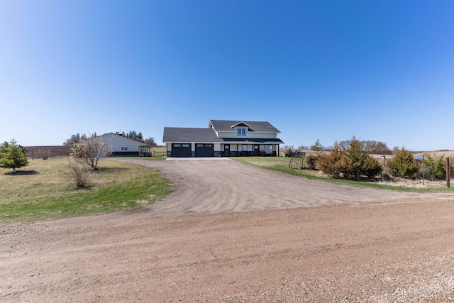 view of front of house with a garage and dirt driveway