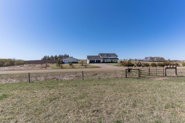 view of yard featuring fence, driveway, and a rural view