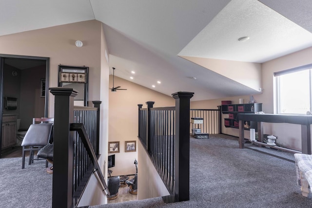 hallway featuring carpet, vaulted ceiling, recessed lighting, and an upstairs landing