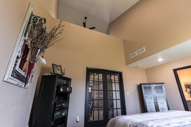 bedroom featuring visible vents and a towering ceiling