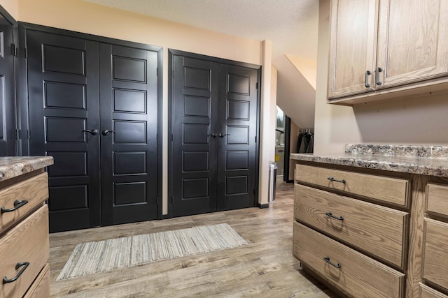 interior space featuring light stone counters and light wood-style flooring