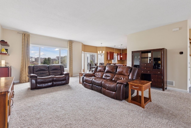 living area with an inviting chandelier, light carpet, baseboards, and visible vents