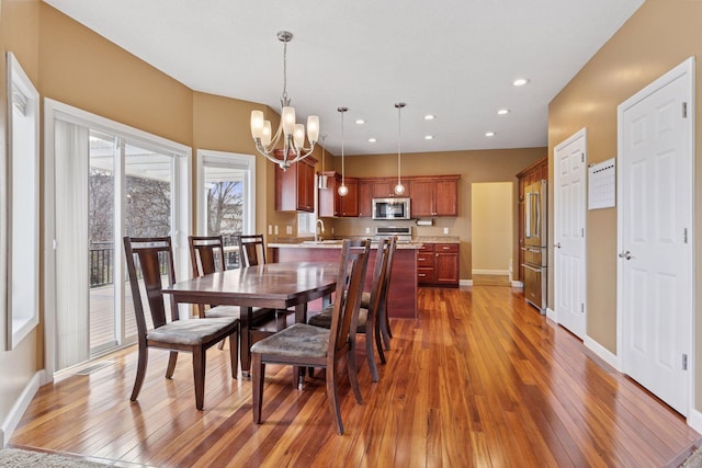 dining area featuring baseboards, dark wood-style flooring, a notable chandelier, and recessed lighting