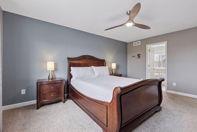 bedroom featuring visible vents, baseboards, ceiling fan, light colored carpet, and ensuite bath
