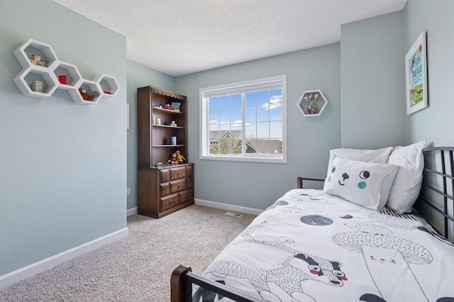 bedroom featuring a textured ceiling, visible vents, baseboards, and carpet floors