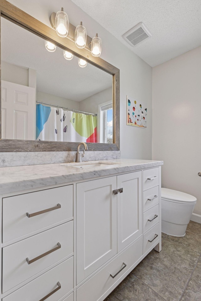 full bath with toilet, vanity, and visible vents
