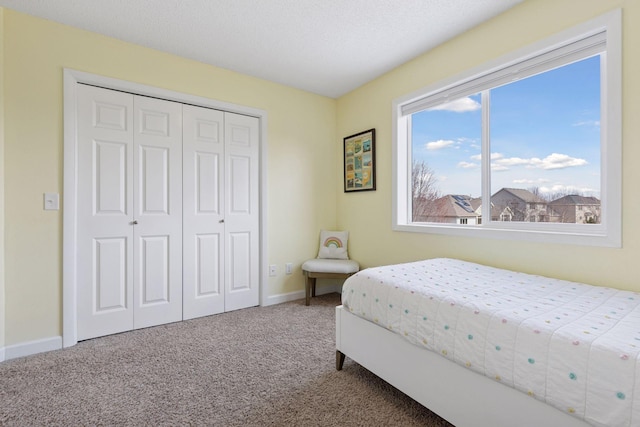 bedroom with carpet, a closet, and baseboards