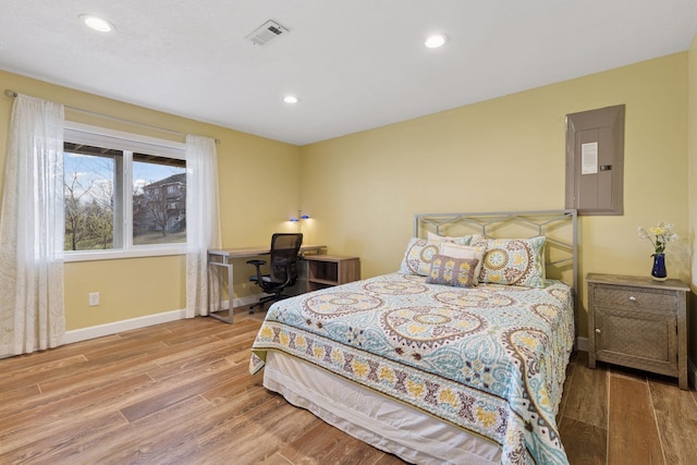 bedroom featuring recessed lighting, baseboards, visible vents, electric panel, and wood finished floors