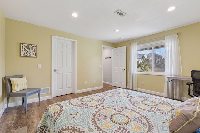 bedroom featuring visible vents, wood finished floors, baseboards, and recessed lighting