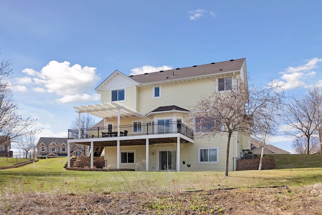 back of property featuring a lawn, a wooden deck, and a pergola