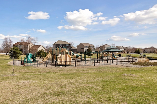 community jungle gym featuring fence, a residential view, and a lawn