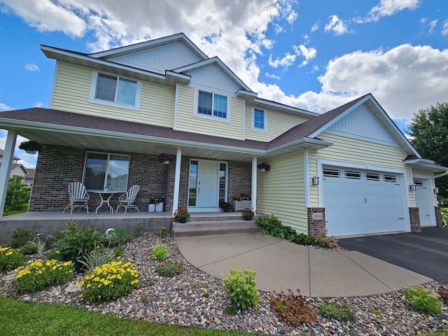 view of front of house featuring a porch, an attached garage, brick siding, driveway, and board and batten siding