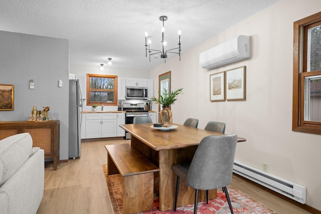 23245 County Rd W, Grantsburg, WI 54840 - dining room with a wall mounted air conditioner, light wood-style floors, baseboard heating, a chandelier, and a textured ceiling