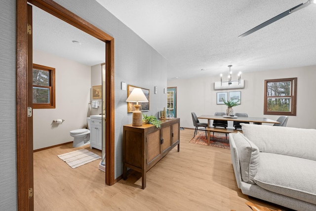 23245 County Rd W, Grantsburg, WI 54840 - hall featuring light wood-type flooring, a textured ceiling, and a chandelier
