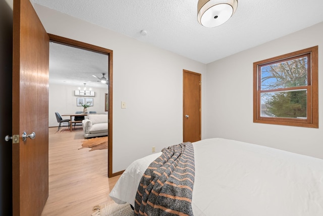 23245 County Rd W, Grantsburg, WI 54840 - bedroom featuring light wood-style flooring, a textured ceiling, and a chandelier