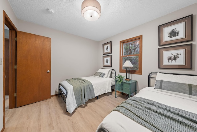 23245 County Rd W, Grantsburg, WI 54840 - bedroom featuring light wood-style flooring, a textured ceiling, and baseboards