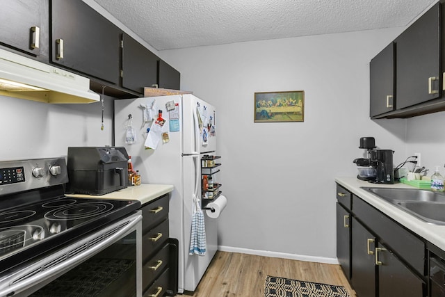 kitchen with electric range, light wood-type flooring, a sink, light countertops, and under cabinet range hood
