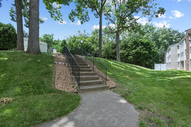 view of community featuring stairs and a lawn