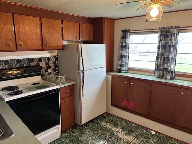 10010 Lake Rd, Watab Twp, MN 56367 - kitchen with a ceiling fan, freestanding refrigerator, light countertops, electric stove, and exhaust hood