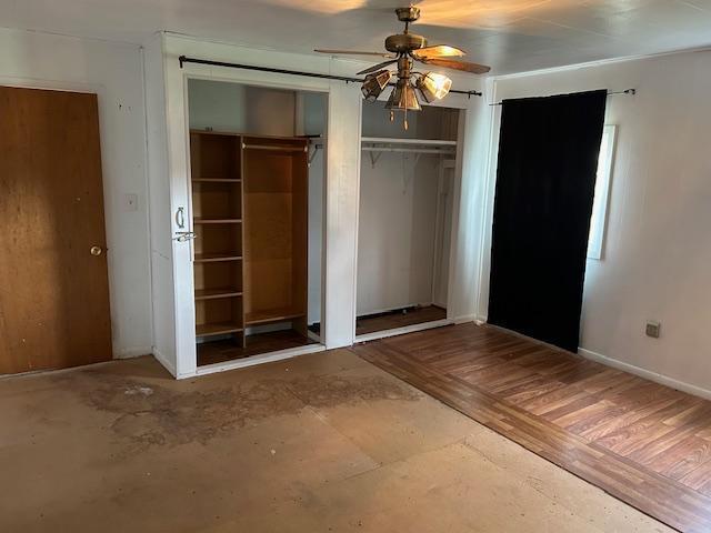 10010 Lake Rd, Watab Twp, MN 56367 - unfurnished bedroom featuring a ceiling fan, baseboards, and multiple closets