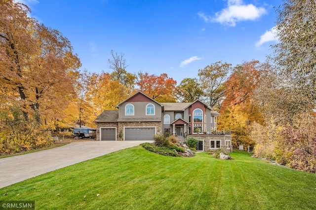 view of front of property featuring an attached garage, a front lawn, driveway, and stone siding