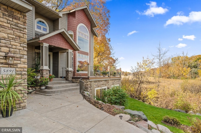 property entrance featuring covered porch and stone siding