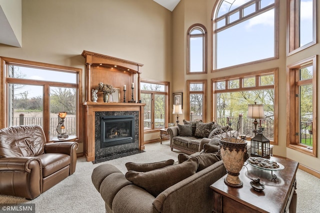 living area with carpet flooring, a high ceiling, and a fireplace