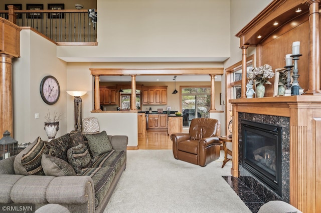 living room with a high ceiling, light colored carpet, and a fireplace